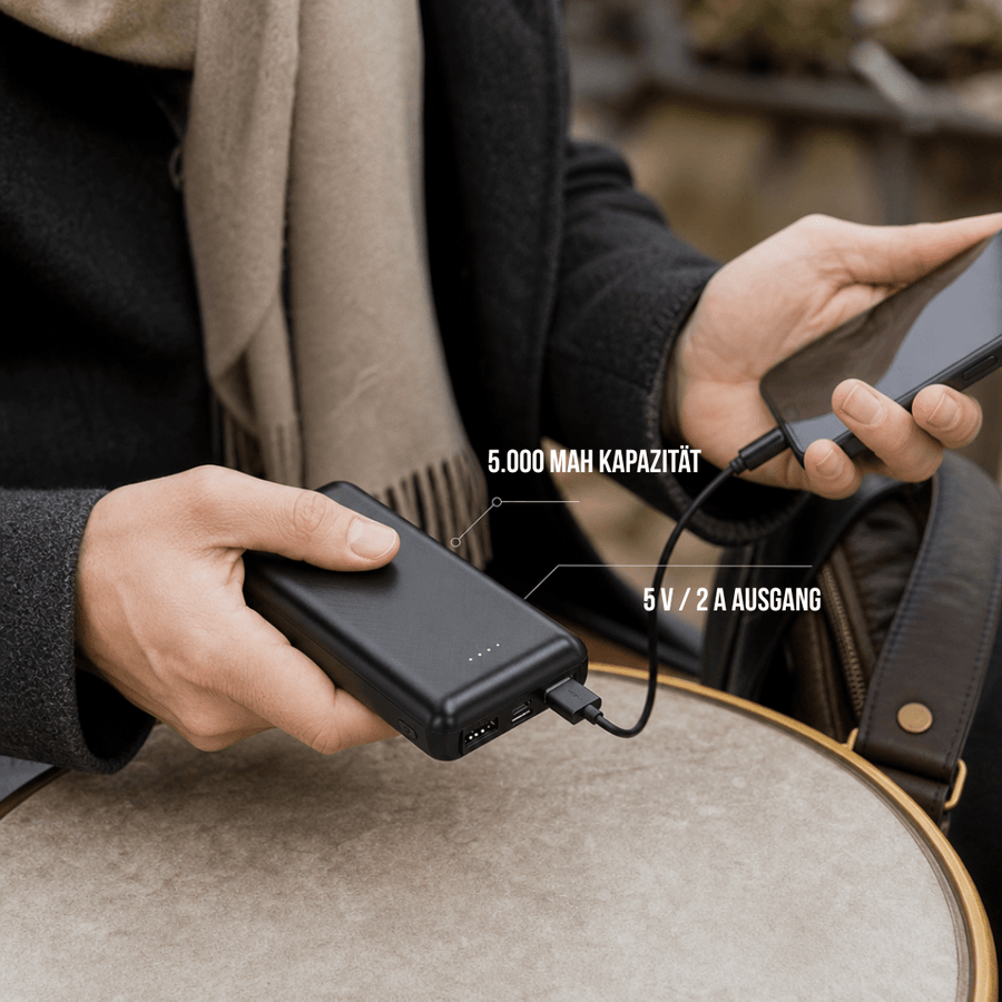 Powerbank mit eingestecktem Kabel in der Hand